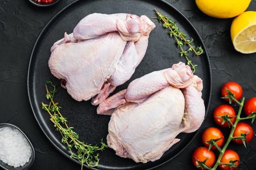 Organic whole fresh poussins with herbs spices, on black background, top view