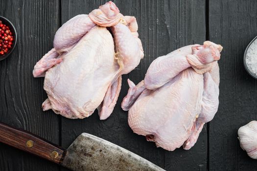 Fresh raw chicken meat with herbs spices, on black wooden table, top view