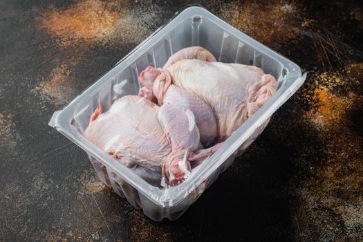 Raw chicken set in plastic vacuum tray, on old rustic background