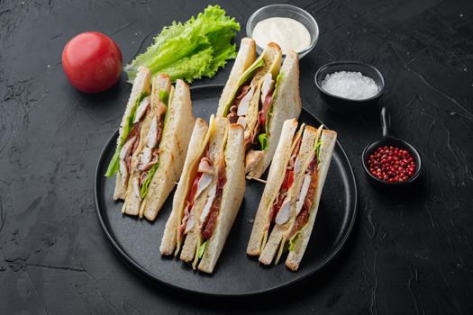 Club sandwich panini with ham, fresh tomato, cheese, on black background