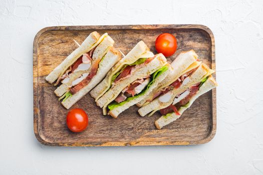 Halves of fresh club sandwiches, on white background, top view
