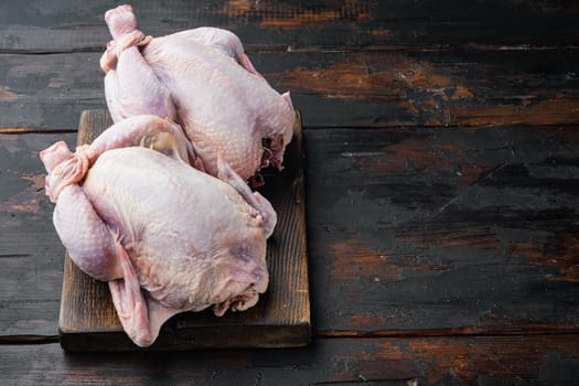 Raw coquelet chickens meat, on old wooden table with copy space for text