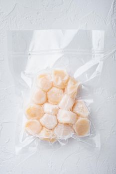 Scallops, in vacuum pack, top view, on white textured background