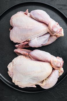 Raw organic uncooked whole chicken meat, on black background, top view