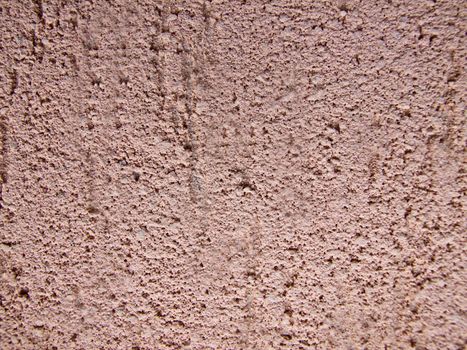 The facade of the house is plastered with decorative brown plaster.Texture or background