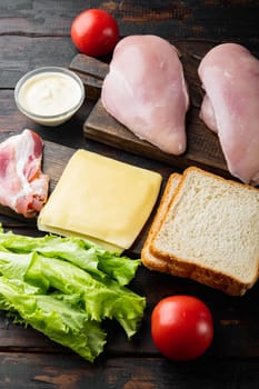 Ingredients for sandwich, bacon, cheese, tomato, chicken meat, lettuce, sauce, on old wooden table