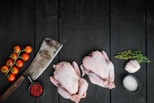Raw small young whole chicken with herbs spices, on black wooden background, top view with copy space for text