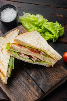 Classic club sandwich with meat, on dark wooden background