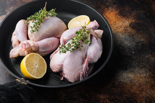 Organic whole fresh poussins on grill pan, on old rustic background with copy space for text