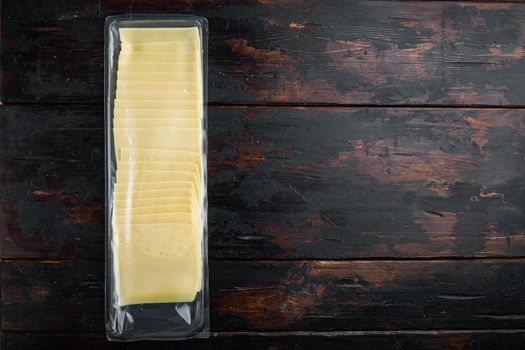 Cheddar cheese in vacuum pack, on dark wooden background with copy space for text