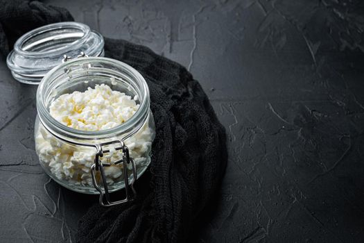 Cottage cheese, curd, on black textured background with space for text