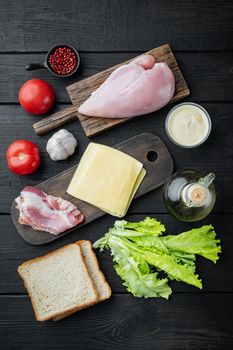 Club sandwich with fresh ingredient, on black wooden background, top view