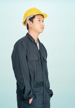 Young man in coveralls helmet hardhat isolated on blue background