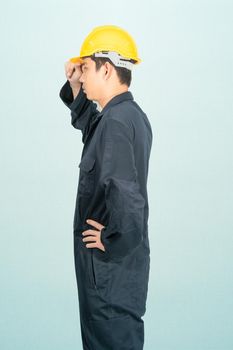 Young man in coveralls helmet hardhat isolated on blue background