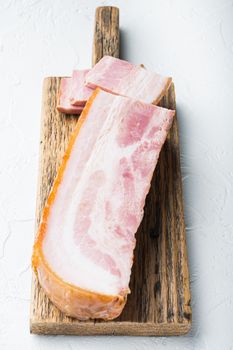 Smoked bacon, whole slab on white background.