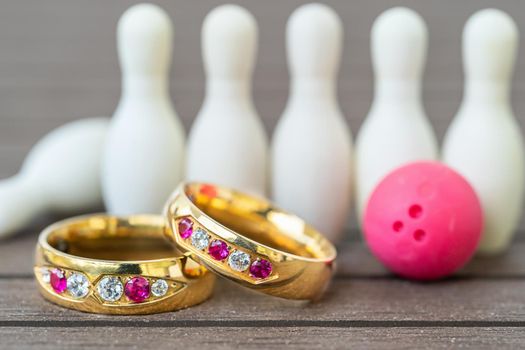 Close up shot wedding rings with bowling pin background