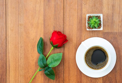 White cup of coffee and red rose on wood background valentine concept