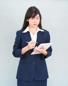 Asian woman in suit using computer digital tablet isolated on gray background