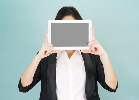 Young asian women in suit holding her digital tablet standing against green background