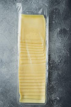 Slices of american cheese plastic pack, on gray background