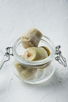 Canned artichokes with olive oil, on white textured background