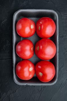 Fresh red organic tomatoes, on black background