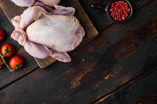 Whole raw free range fresh chicken with ingredients, on old wooden table, top view with copy space for text