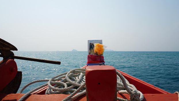 Travel by sea in Thailand by ship. View of the open ocean, green Islands and gray sky in smog. Green water with waves. Sailing between the Islands. Ship from different sides: stern, bow, rope, anchor.