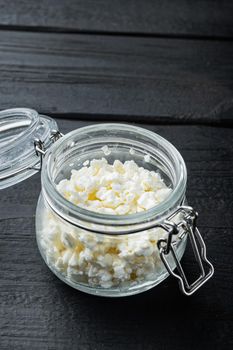 Cottage cheese, curd, on black wooden table