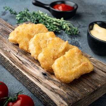 Nuggets breaded on grey background.