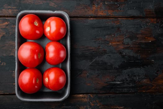 Red ripe tomatoes, on dark wooden background with copy space for text