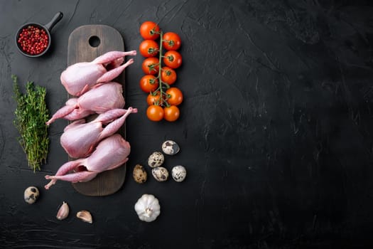 Whole quails meat with spices, herbs, vegetables, top view, on black textured background with copy space