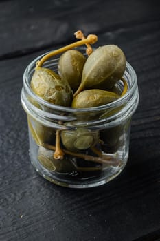 Organic pickled, canned capers, on black wooden background