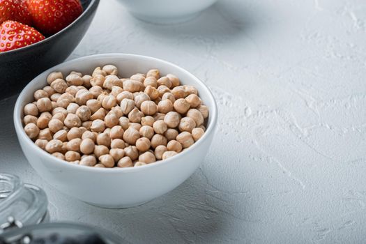 Chickpea in white bowl with space for text, on white background.