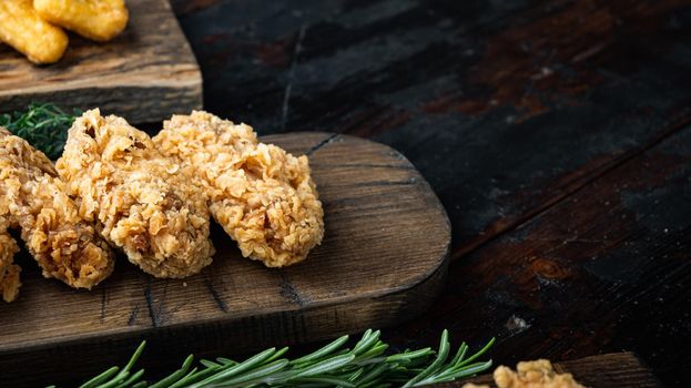 Fried chicken wings parts on old dark wooden table, with copy space.