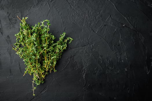 Thyme green fresh bunch, on black background, top view with copy space for text