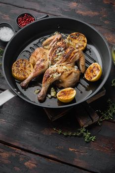 Spatchcocked poussins, with chimichurri sauce, on old wooden table with copy space for text