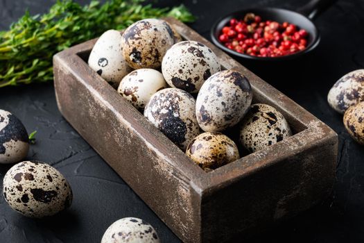 Fresh quails eggs, on black textured background