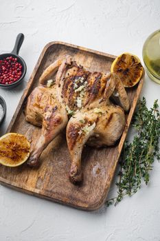 Butterflied rotisserie chicken with crispy golden skin, on white background