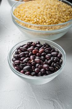 Red beans in bowl with healthy ingredients, on white background.