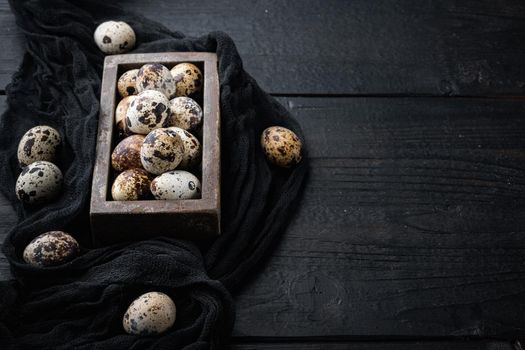 Organic quails eggs, on black wooden background with space for text