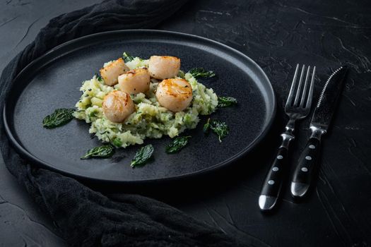 Grilled scallops with mashed potatoes, on black textured background