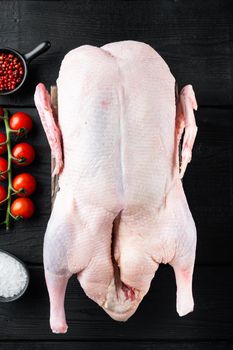 Raw whole farm duck meat on black wooden table, top view.