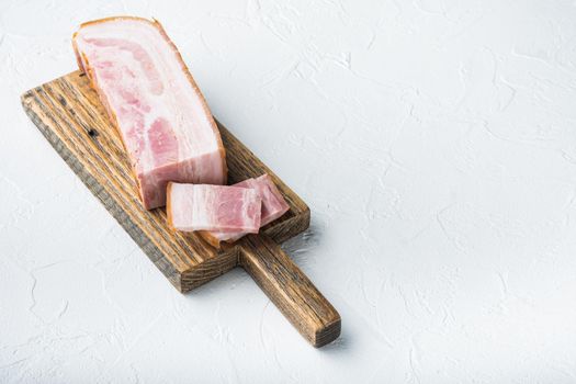 Smoked bacon, whole slab on white background with space for text.