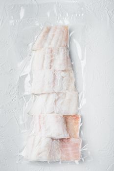 Raw haddock fish skinless plastic vacuum packaged, on white background, top view