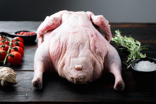 Raw whole farm duck meat on dark wooden background.