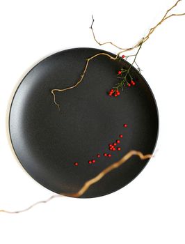 Ikebana with black round plate, Japanese bamboo on white background. Japanese inspiration, ikebana. elegant floral arrangement