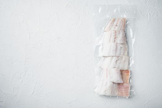 Haddock white fish fillet in plastic market package, on white background, top view with copy space for text