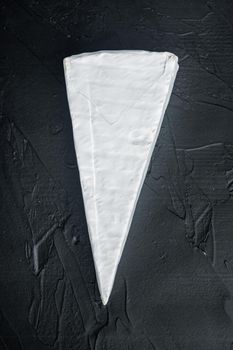 Piece of the brie cheese set, on black background, top view