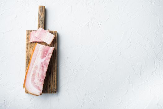 Bacon pancetta cut and sliced on white background, top view with space for text.